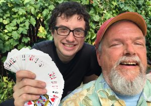 Excellent home care worker, Ian, poses by our grape arbor with two decks of cards and double-deck memorizer, me, David W. Oaks.
